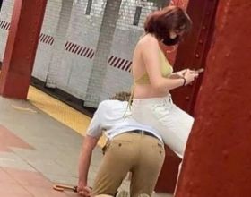 男子跪地鐵月臺旁邊，女子坐他背上玩手機