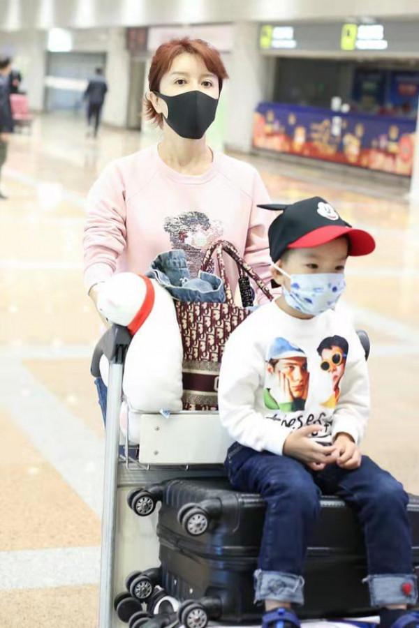 金巧巧罕見帶兒子走機場留長髮穿粉衣大變樣，兒子顏值被爸爸拉垮