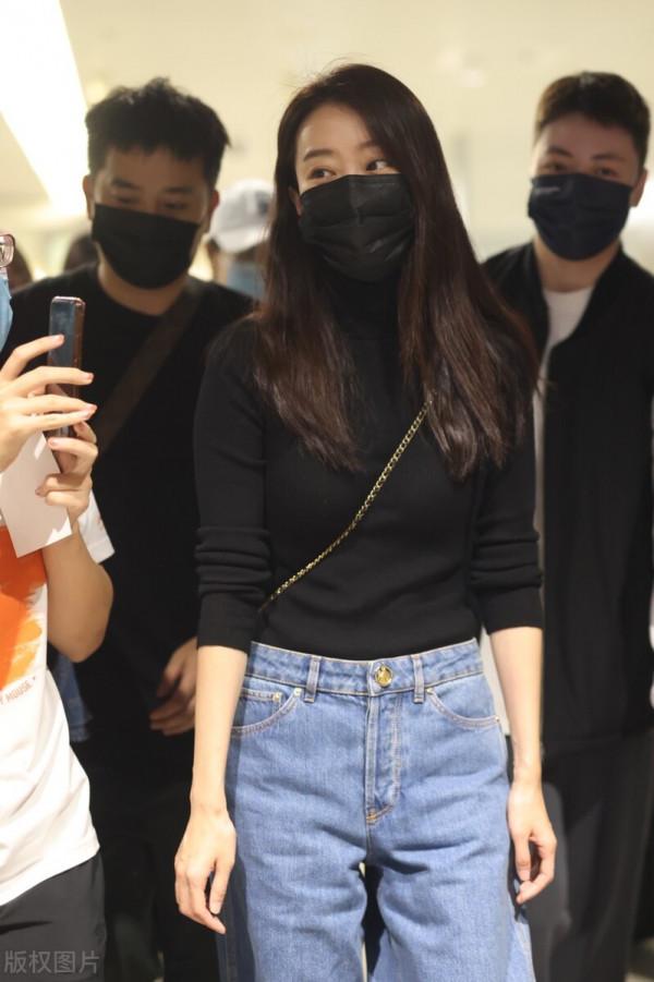 張小斐穿黑色針織衫搭配牛仔褲，長髮披肩不失女人味