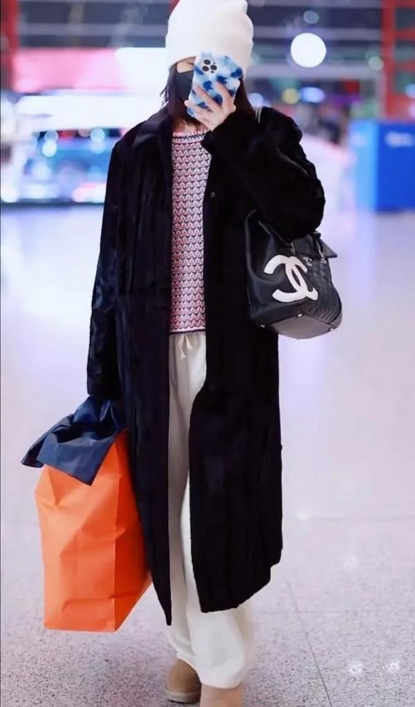 吳昕私服秀，身穿黑色大衣，揹著名牌包，身材超棒，忙著微信聊天