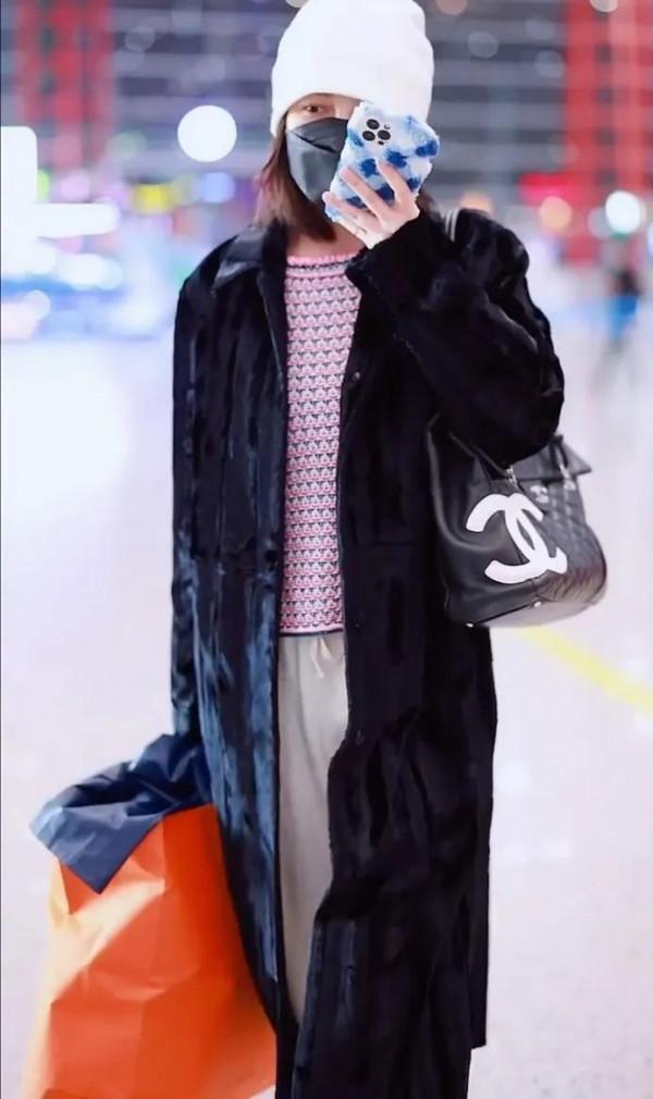 吳昕私服秀，身穿黑色大衣，揹著名牌包，身材超棒，忙著微信聊天