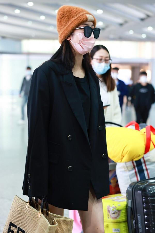 趙小棠穿黑色西裝外套，腳踩棕色高筒靴，手提超大托特包帥氣十足