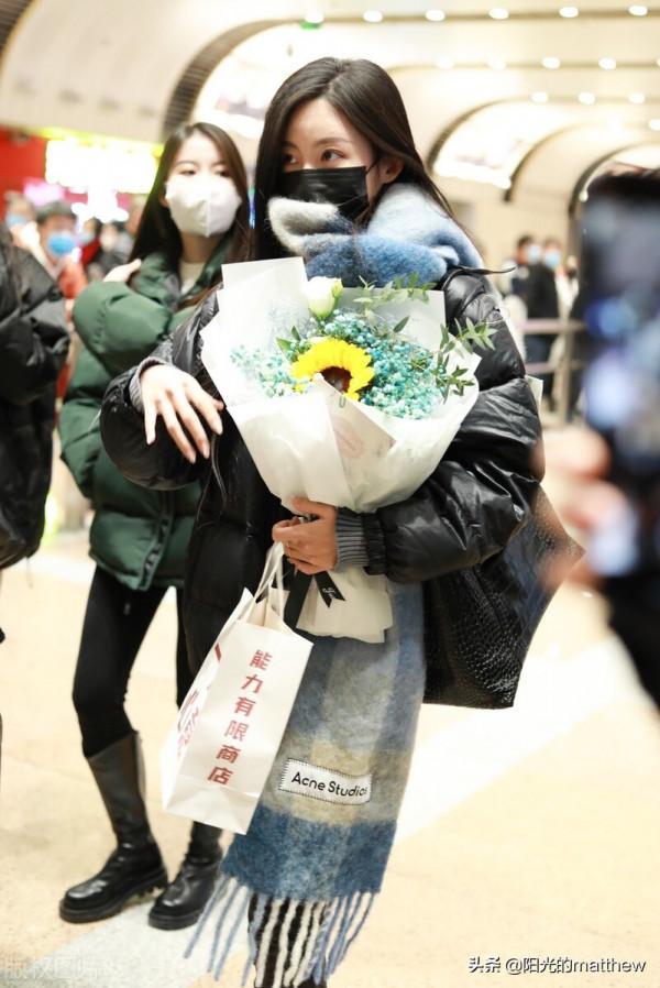 街拍：孫茵身穿黑色羽絨服搭鉛筆褲手捧鮮花人氣旺