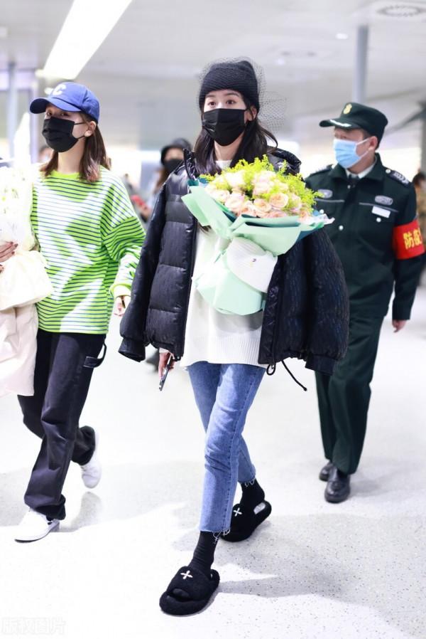 袁冰妍穿羽絨服搭配牛仔褲，腳踩毛絨拖鞋，戴網紗毛線帽很時髦