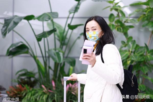 陶虹穿白色刺繡羽絨服趕飛機 戴卡通口罩難掩笑容