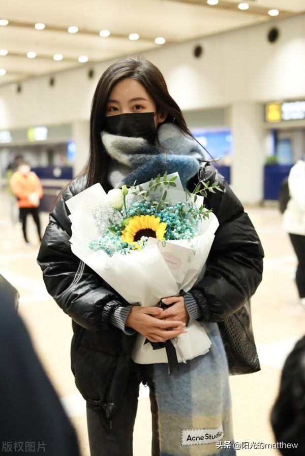 街拍：孫茵身穿黑色羽絨服搭鉛筆褲手捧鮮花人氣旺