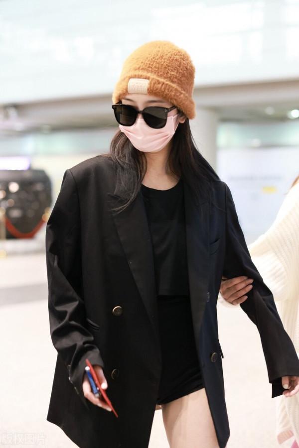 趙小棠穿黑色西裝外套，腳踩棕色高筒靴，手提超大托特包帥氣十足