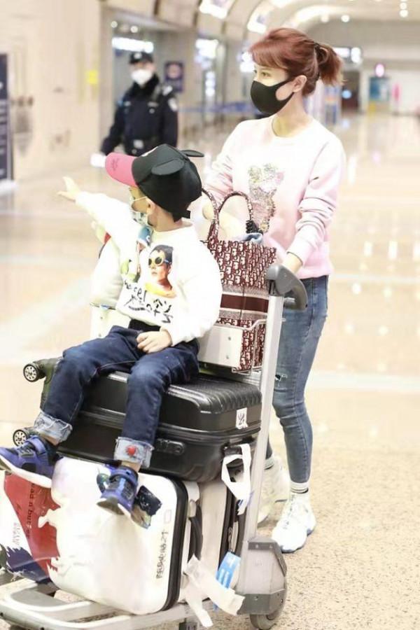 金巧巧罕見帶兒子走機場留長髮穿粉衣大變樣，兒子顏值被爸爸拉垮