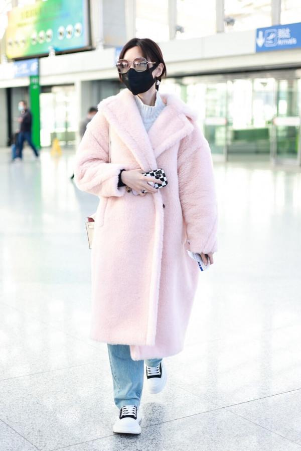 毛曉彤穿粉色毛呢大衣搭配牛仔褲，戴茶色墨鏡很時髦