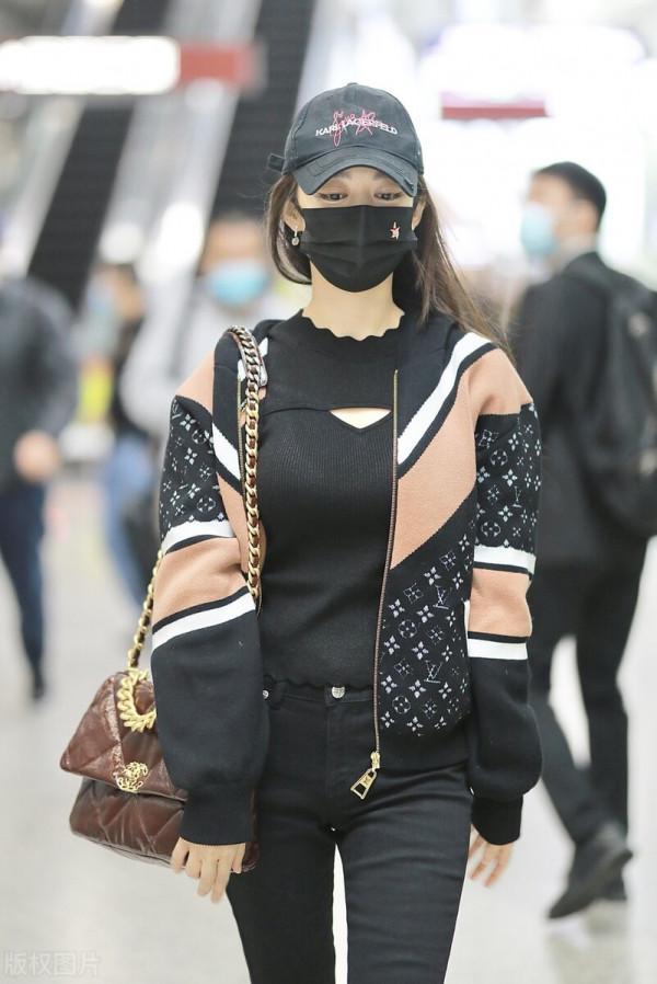 吉娜穿拼接拉鍊外套搭配黑色喇叭褲，單肩挎漆皮鏈條包很時髦