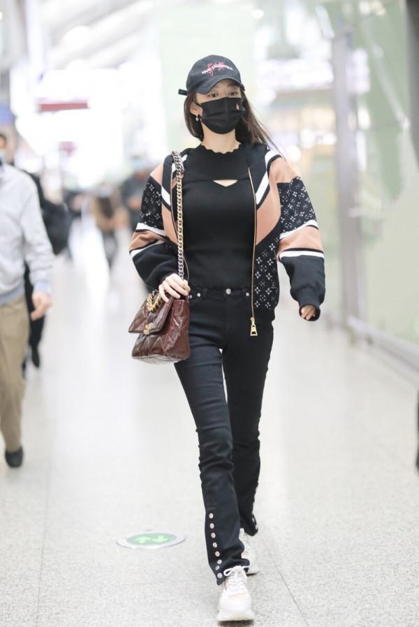 吉娜穿拼接拉鍊外套搭配黑色喇叭褲，單肩挎漆皮鏈條包很時髦