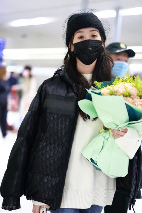 袁冰妍穿羽絨服搭配牛仔褲，腳踩毛絨拖鞋，戴網紗毛線帽很時髦