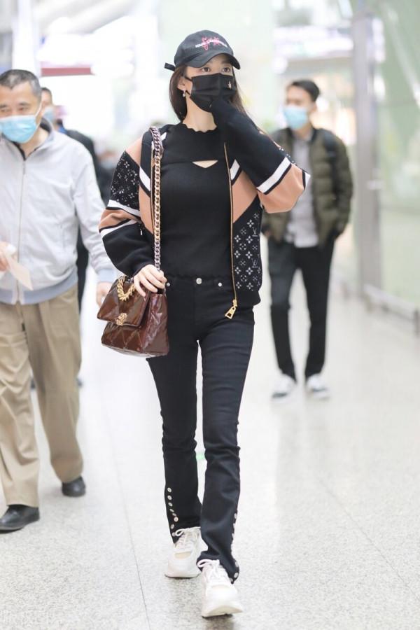 吉娜穿拼接拉鍊外套搭配黑色喇叭褲，單肩挎漆皮鏈條包很時髦