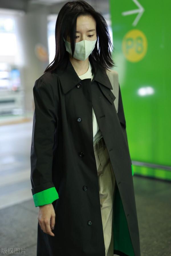 董潔穿黑色小翻領風衣搭配卡其色闊腿長褲，腳踩小白鞋休閒隨性