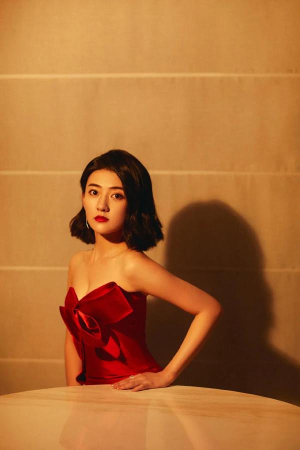 梁潔百褶裙氣質清雅，一頭微卷短髮精緻時髦，隨意撩耳後優雅美麗