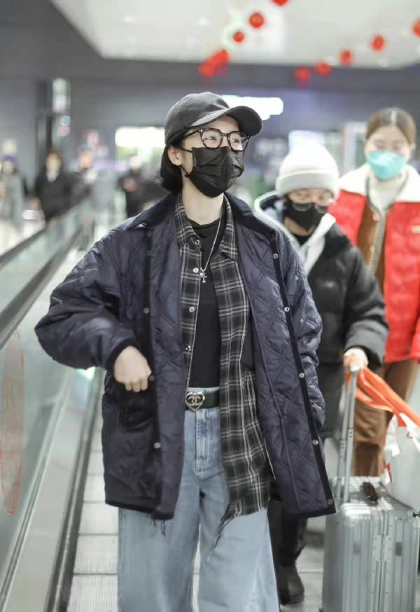 周雨彤藏青色薄款羽絨服疊穿格子衫和闊腿牛仔褲，充滿時尚街頭風