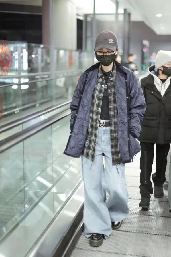 周雨彤藏青色薄款羽絨服疊穿格子衫和闊腿牛仔褲，充滿時尚街頭風