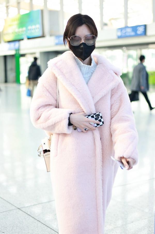 毛曉彤穿粉色毛呢大衣搭配牛仔褲，戴茶色墨鏡很時髦