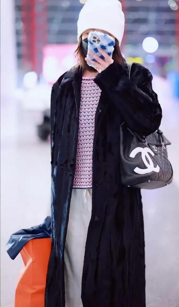 吳昕私服秀，身穿黑色大衣，揹著名牌包，身材超棒，忙著微信聊天
