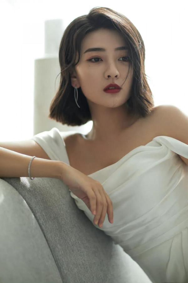 梁潔百褶裙氣質清雅，一頭微卷短髮精緻時髦，隨意撩耳後優雅美麗