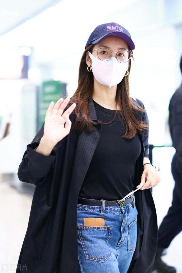 呂一穿黑色風衣搭配藍色牛仔褲,戴棒球帽簡約時尚 呂一穿黑色風衣搭配藍色牛仔褲,戴棒球帽簡約時尚