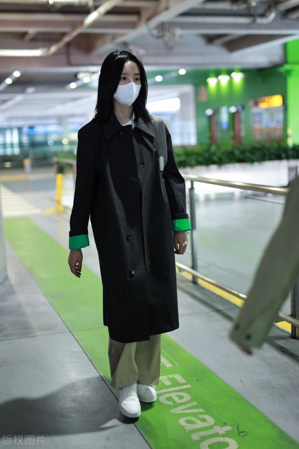 董潔穿黑色小翻領風衣搭配卡其色闊腿長褲，腳踩小白鞋休閒隨性