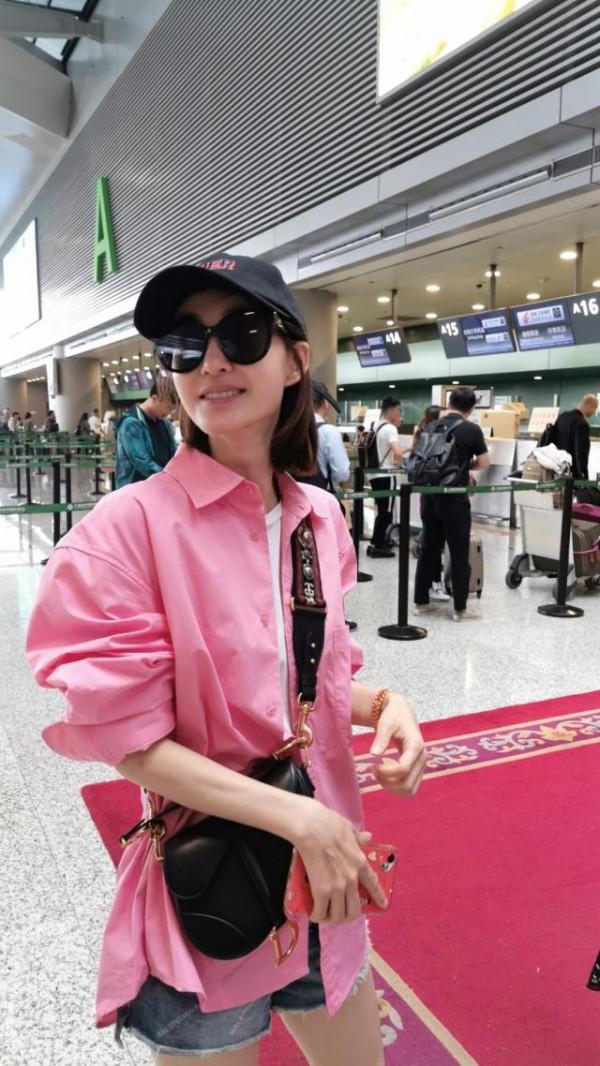 “素顏女神”王麗坤走機場，穿粉襯衫配牛仔短褲，瞬間嫩回十八歲