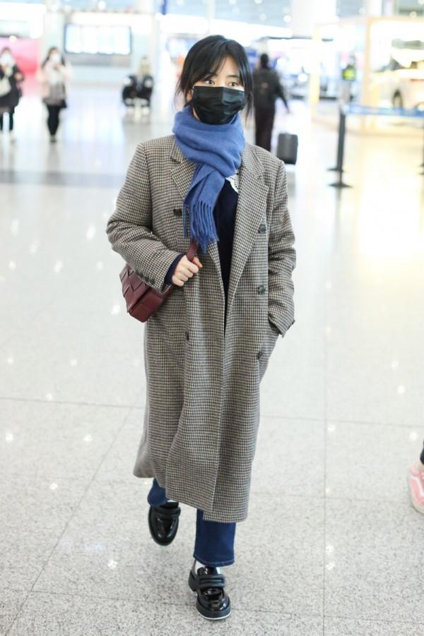 譚松韻穿格紋大衣搭配牛仔褲，系藍色圍巾，腳踩樂福鞋輕鬆隨性