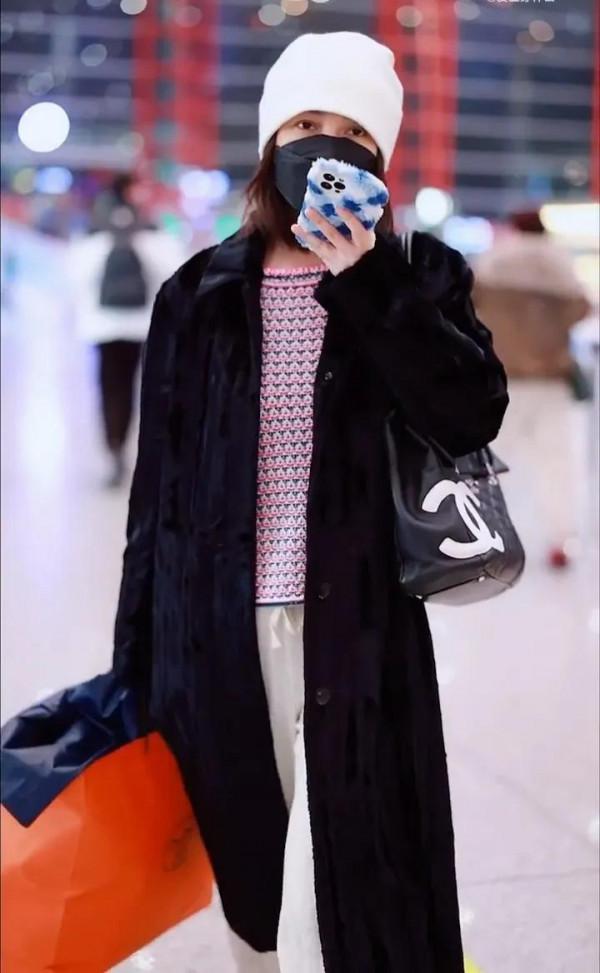 吳昕私服秀，身穿黑色大衣，揹著名牌包，身材超棒，忙著微信聊天