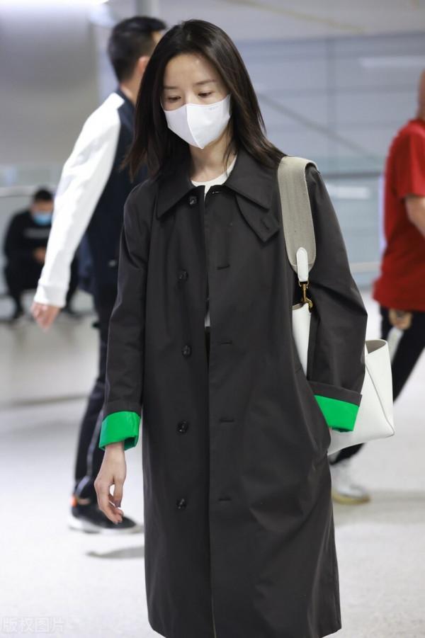 董潔穿黑色小翻領風衣搭配卡其色闊腿長褲，腳踩小白鞋休閒隨性