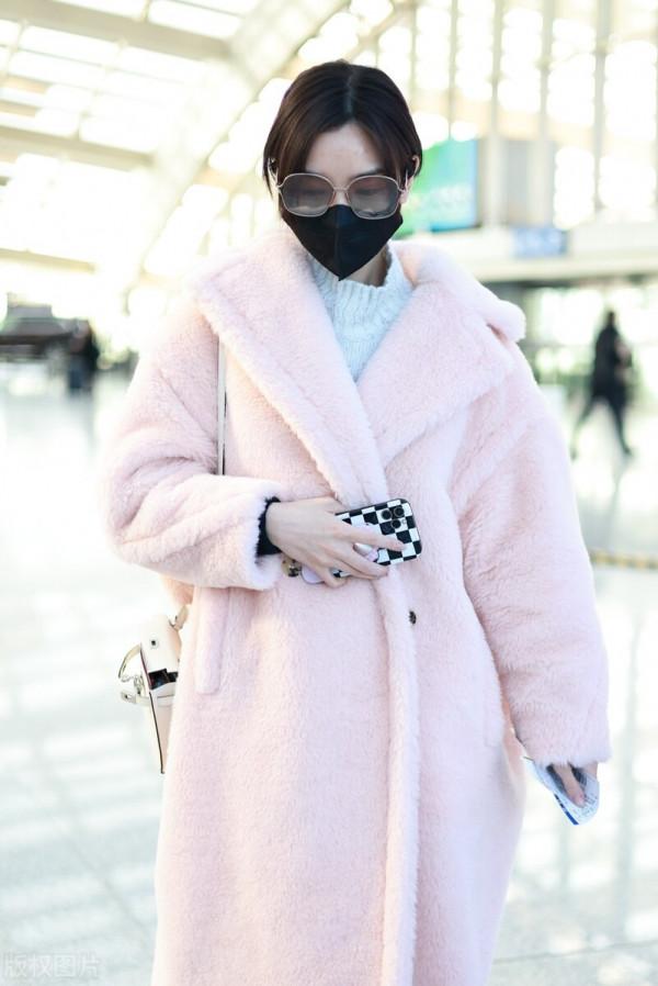 毛曉彤穿粉色毛呢大衣搭配牛仔褲，戴茶色墨鏡很時髦
