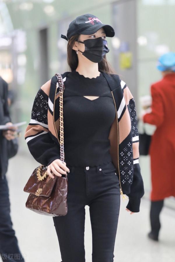 吉娜穿拼接拉鍊外套搭配黑色喇叭褲，單肩挎漆皮鏈條包很時髦