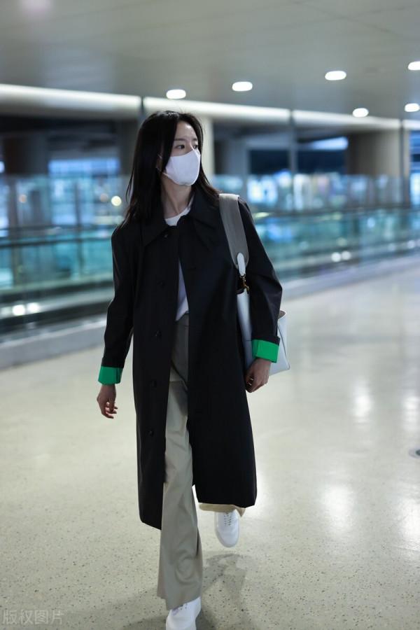 董潔穿黑色小翻領風衣搭配卡其色闊腿長褲，腳踩小白鞋休閒隨性