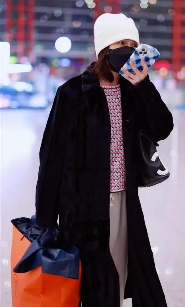吳昕私服秀，身穿黑色大衣，揹著名牌包，身材超棒，忙著微信聊天