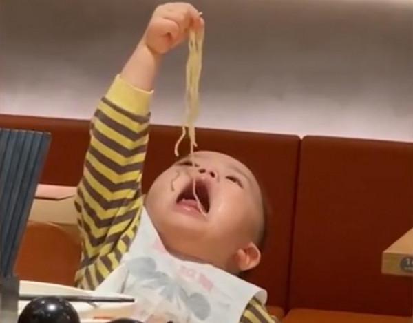 山東一萌娃給自己喂麵條，頭抬得老高半天吃不到，網友：講究人