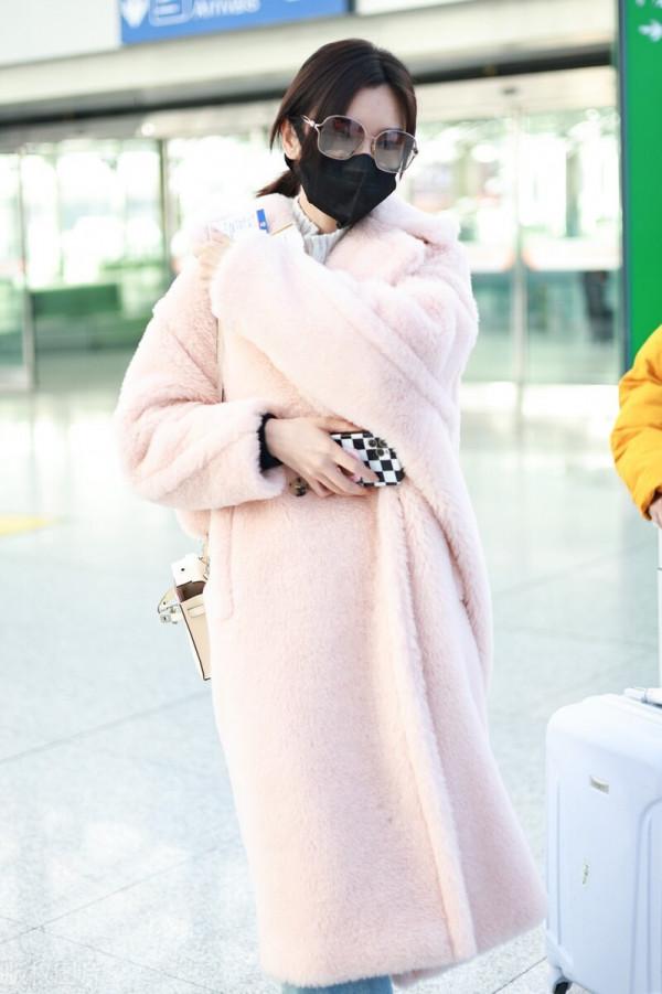 毛曉彤穿粉色毛呢大衣搭配牛仔褲，戴茶色墨鏡很時髦