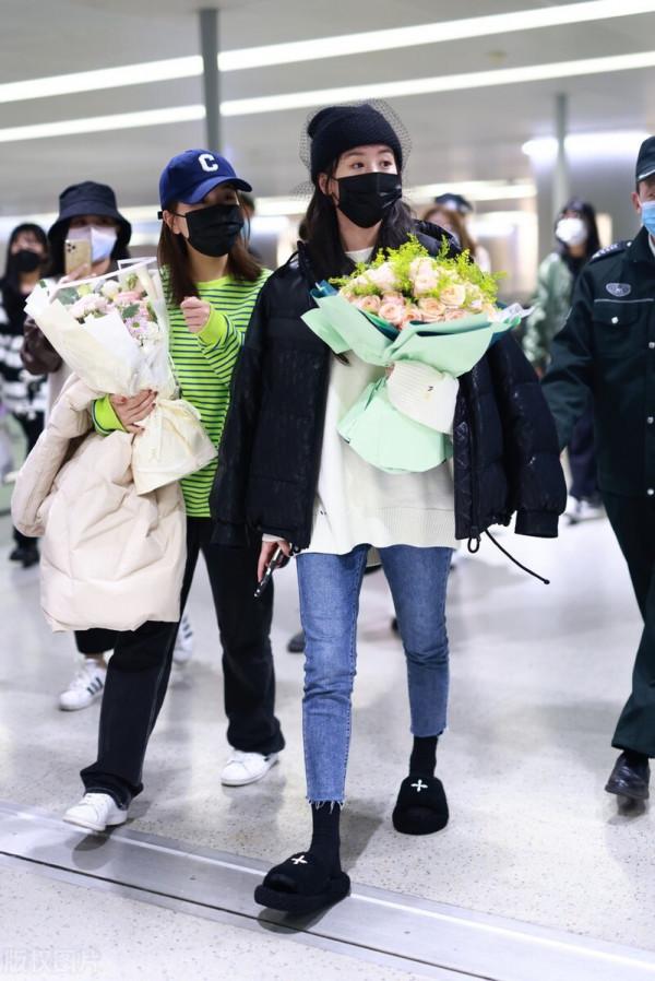 袁冰妍穿羽絨服搭配牛仔褲，腳踩毛絨拖鞋，戴網紗毛線帽很時髦