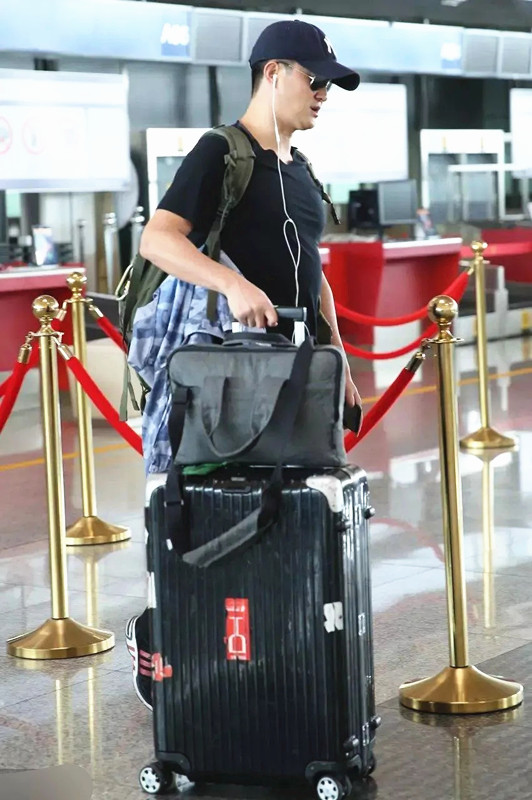 “百億影帝”吳京真低調，獨自走機場無助理保鏢，張譯同行顯樸素