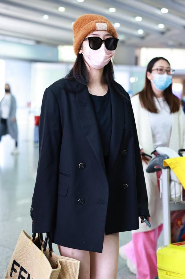 趙小棠穿黑色西裝外套，腳踩棕色高筒靴，手提超大托特包帥氣十足