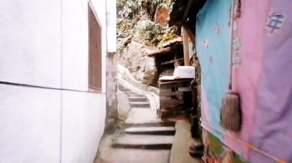 在武漢鬧市攀登一條山路，地勢崎嶇樹林茂盛，斑駁舊民房塵封時光