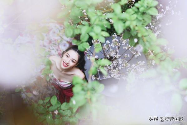 鍾楚曦一襲花瓣抹胸裙，隱藏在花叢中嬌媚動人