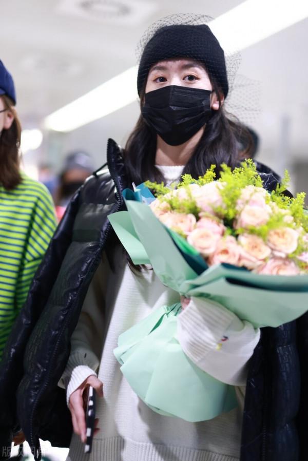 袁冰妍穿羽絨服搭配牛仔褲，腳踩毛絨拖鞋，戴網紗毛線帽很時髦