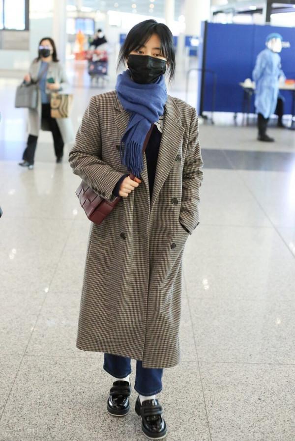 譚松韻穿格紋大衣搭配牛仔褲，系藍色圍巾，腳踩樂福鞋輕鬆隨性