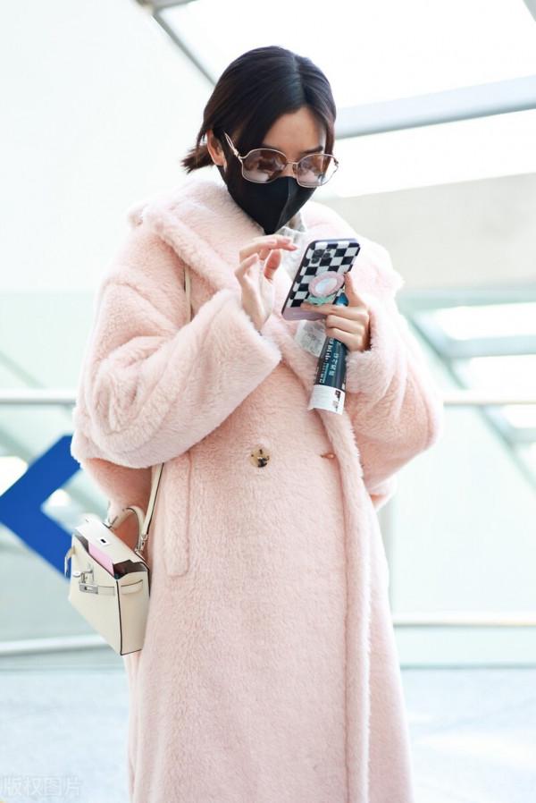 毛曉彤穿粉色毛呢大衣搭配牛仔褲，戴茶色墨鏡很時髦
