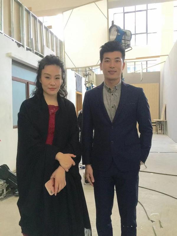 鄔君梅跟男演員合影，55歲容顏自然真實，穿大衣氣質端莊優雅