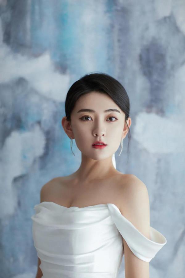 梁潔百褶裙氣質清雅，一頭微卷短髮精緻時髦，隨意撩耳後優雅美麗