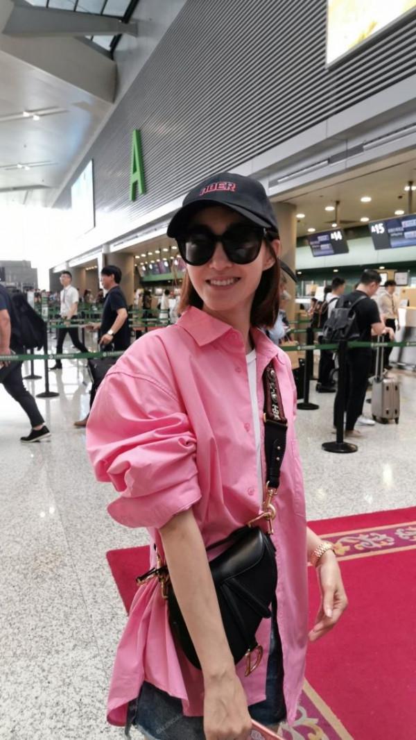 “素顏女神”王麗坤走機場，穿粉襯衫配牛仔短褲，瞬間嫩回十八歲