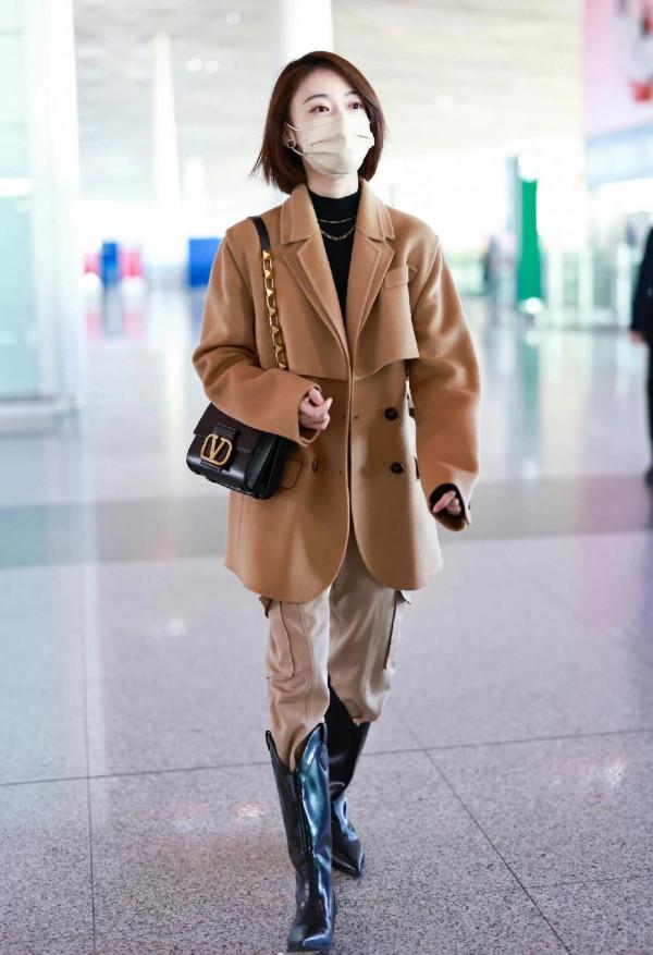 吳謹言私服，身穿呢子大衣腳套大長靴，靴子比包包還要亮