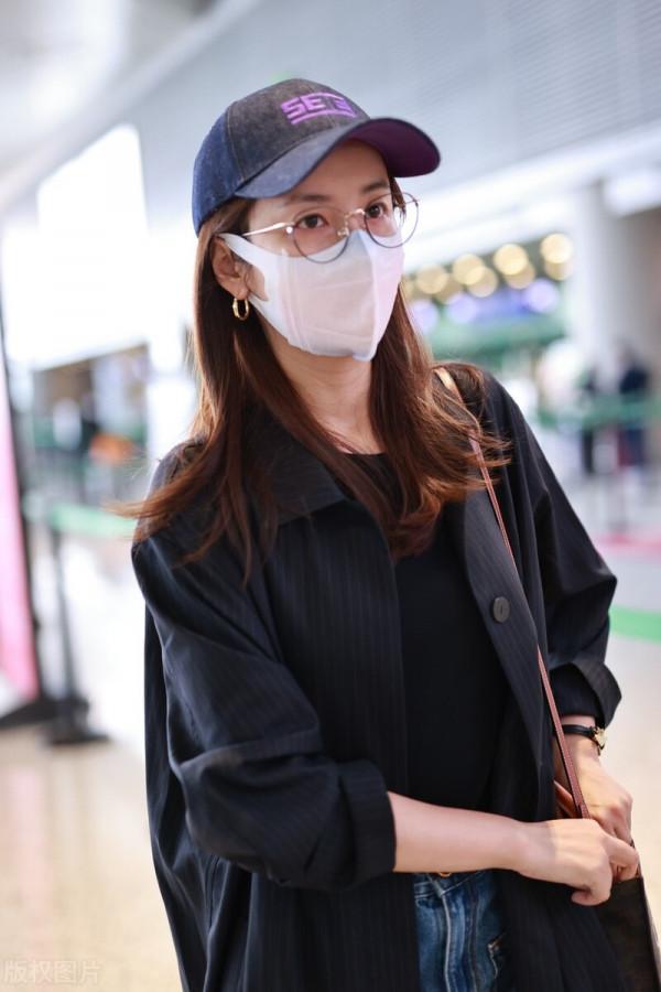 呂一穿黑色風衣搭配藍色牛仔褲,戴棒球帽簡約時尚 呂一穿黑色風衣搭配藍色牛仔褲,戴棒球帽簡約時尚