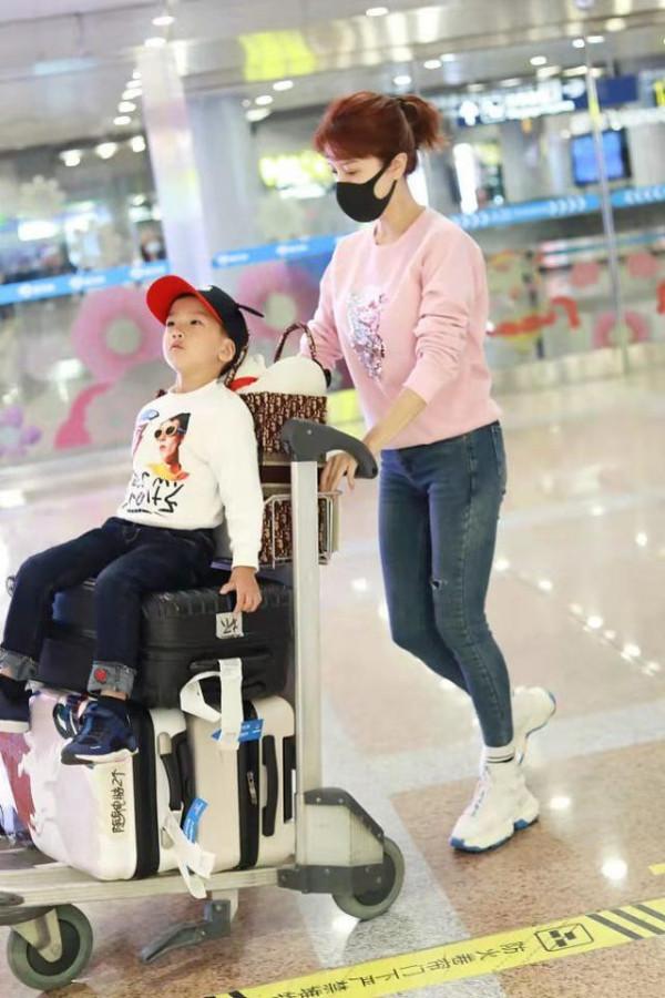 金巧巧罕見帶兒子走機場留長髮穿粉衣大變樣，兒子顏值被爸爸拉垮